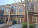 Townhome exterior with garages, upper-level decks, neutral siding, brick accents, and well-maintained landscaping at 10856 Ellicot Way, Alpharetta, GA 30022