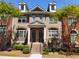 Charming townhome featuring a brick facade, dormer windows and landscaped front yard at 10856 Ellicot Way, Alpharetta, GA 30022