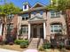 Charming townhome featuring a brick facade, dormer windows and landscaped front yard at 10856 Ellicot Way, Alpharetta, GA 30022