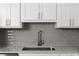 Kitchen sink with stainless steel hardware, gray subway tile backsplash, and elegant white cabinets at 1724 Gunnin Nw Trce # 232, Atlanta, GA 30318