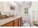 Well-lit bathroom with granite counters, warm wood cabinets, and a large mirror at 1824 Mcclung Rd, Hiram, GA 30141