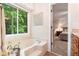 Bright bathroom features a soaking tub with a view of the trees, next to the main bedroom at 1824 Mcclung Rd, Hiram, GA 30141