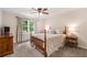 Comfortable bedroom with neutral carpet, wood furniture, large window, and ceiling fan at 1824 Mcclung Rd, Hiram, GA 30141