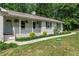 Close-up view of the cozy front porch with hanging plants and a sidewalk leading to the front door at 1824 Mcclung Rd, Hiram, GA 30141
