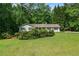 Charming single-story home with a lush green lawn and mature landscaping in a serene, wooded setting at 1824 Mcclung Rd, Hiram, GA 30141