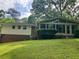 Backyard view of a home with a spacious sunroom and well-maintained lawn at 215 N Etowah Ct, Canton, GA 30114