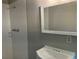 A cozy bathroom featuring a single sink, white tile shower, and a mirror at 215 N Etowah Ct, Canton, GA 30114