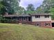 Traditional two-story home featuring a brick and vinyl facade, dark shutters, and mature trees at 215 N Etowah Ct, Canton, GA 30114