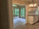 Bright kitchen features modern light fixture, neutral cabinets and floors with views to the sunroom at 215 N Etowah Ct, Canton, GA 30114