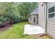 View of the back of the house and backyard with concrete patio, grassy area, and landscaping at 3314 Dilmus Dr, Powder Springs, GA 30127