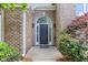Close-up of the front door featuring an arched window, sidelights, and classic brick surround at 3314 Dilmus Dr, Powder Springs, GA 30127