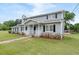 Two-story home featuring a well-manicured lawn, mature trees, and charming architectural details at 100 Fairview Dr, Stockbridge, GA 30281