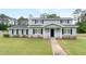 Charming two-story home with a cozy front porch and a well-maintained lawn and manicured shrubs at 100 Fairview Dr, Stockbridge, GA 30281