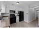 Modern kitchen with white cabinets, stainless sink, black appliances, and ample counter space at 100 Fairview Dr, Stockbridge, GA 30281