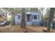 Exterior view of a blue home with bars on the windows, surrounded by trees at 1182 Bronx Nw St, Atlanta, GA 30314