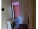 View of hallway with peeling walls, bare floors, and an old-fashioned heater, requiring extensive renovation at 1182 Bronx Nw St, Atlanta, GA 30314