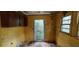 The yellow kitchen has damaged walls, damaged flooring and a view to the backyard at 1182 Bronx Nw St, Atlanta, GA 30314