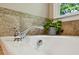 Close up on the bathtub with a chrome faucet and garden view at 2078 Marshalls Se Ln, Atlanta, GA 30316