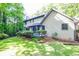 Lush backyard with lawn and patio blending seamlessly with the trees beyond at 4953 Mcpherson Ne Dr, Roswell, GA 30075