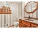 Bathroom features vintage wallpaper, a wooden vanity, and a shuttered window at 4953 Mcpherson Ne Dr, Roswell, GA 30075