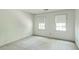Bright bedroom featuring neutral carpet and two windows with roller shades at 4953 Mcpherson Ne Dr, Roswell, GA 30075