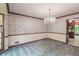 Dining room features decorative wallpaper, chair rail, and elegant chandelier at 4953 Mcpherson Ne Dr, Roswell, GA 30075