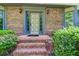 Elegant front entrance featuring brick steps, a decorative door, and manicured shrubs for added curb appeal at 4953 Mcpherson Ne Dr, Roswell, GA 30075