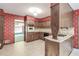 Retro kitchen featuring floral wallpaper, wood cabinets, and a large opening to another room at 4953 Mcpherson Ne Dr, Roswell, GA 30075