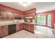 Cozy kitchen with vintage floral wallpaper, wood cabinets, and a tiled floor at 4953 Mcpherson Ne Dr, Roswell, GA 30075