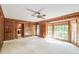 Living room with wood paneling, ceiling fan, and large bay window at 4953 Mcpherson Ne Dr, Roswell, GA 30075