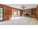 Living room with wood paneling, brick fireplace, and large bay window at 4953 Mcpherson Ne Dr, Roswell, GA 30075