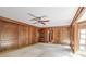Large living room features paneled walls, carpet, ceiling fan, and natural light from window at 4953 Mcpherson Ne Dr, Roswell, GA 30075