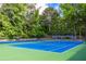 Community tennis courts with lights and surrounded by lush trees at 4953 Mcpherson Ne Dr, Roswell, GA 30075