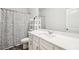Bathroom with a white vanity, mirror, and shower with a decorative curtain, offering a clean aesthetic at 7455 Easton Valley Ln, Cumming, GA 30028
