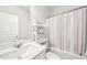 Well-lit bathroom featuring a vanity sink, large mirror, and a shower tub with a striped curtain at 7455 Easton Valley Ln, Cumming, GA 30028