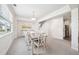 Elegant dining room featuring a large table with seating for eight, a modern chandelier, and stylish decor at 7455 Easton Valley Ln, Cumming, GA 30028