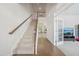 Inviting entryway featuring a staircase with wood handrail, and an open view into other rooms, with hardwood floors at 7455 Easton Valley Ln, Cumming, GA 30028