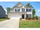 Charming two-story home with a white brick facade, attached garage, manicured lawn, and beautiful landscaping at 7455 Easton Valley Ln, Cumming, GA 30028
