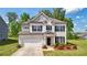 Charming two-story home with a white brick facade, attached garage, manicured lawn, and beautiful landscaping at 7455 Easton Valley Ln, Cumming, GA 30028