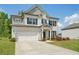 Charming two-story home with a white brick facade, attached garage, manicured lawn, and beautiful landscaping at 7455 Easton Valley Ln, Cumming, GA 30028
