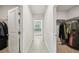 Hallway with tile and carpet flooring and leads to walk in closets and the bathroom at 7455 Easton Valley Ln, Cumming, GA 30028