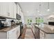Kitchen with granite countertops, white cabinetry, and stainless-steel appliances overlooking the living room at 7455 Easton Valley Ln, Cumming, GA 30028
