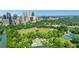 Captivating aerial shot features city skyline and a green park, along with baseball fields, pool and tennis courts at 1055 Piedmont Ne Ave # 409, Atlanta, GA 30309