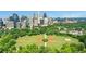 Stunning aerial view showcasing a cityscape, green park with baseball field, and a walking path for recreational activities at 1055 Piedmont Ne Ave # 409, Atlanta, GA 30309