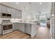 Open kitchen featuring stainless steel appliances, light gray cabinetry, and an island with quartz countertop at 1055 Piedmont Ne Ave # 409, Atlanta, GA 30309