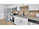 Well-lit kitchen featuring stainless steel appliances, granite countertops, and a stylish brick backsplash at 1839 Belcher Pl, Austell, GA 30168
