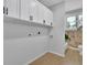 Laundry room with white cabinets and a window with a view of trees and an adjacent bathroom at 1839 Belcher Pl, Austell, GA 30168