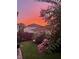 Charming backyard features a lush lawn, flowering tree, and well-maintained landscaping at sunset at 6575 Eli Davis Rd, Cumming, GA 30040