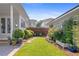 Well-manicured backyard with lush lawn, stone pathway, and vibrant flowering bushes at 6575 Eli Davis Rd, Cumming, GA 30040