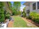 Well-maintained backyard with lawn, plants, stone pathway, landscaping, and a patio with furniture at 6575 Eli Davis Rd, Cumming, GA 30040